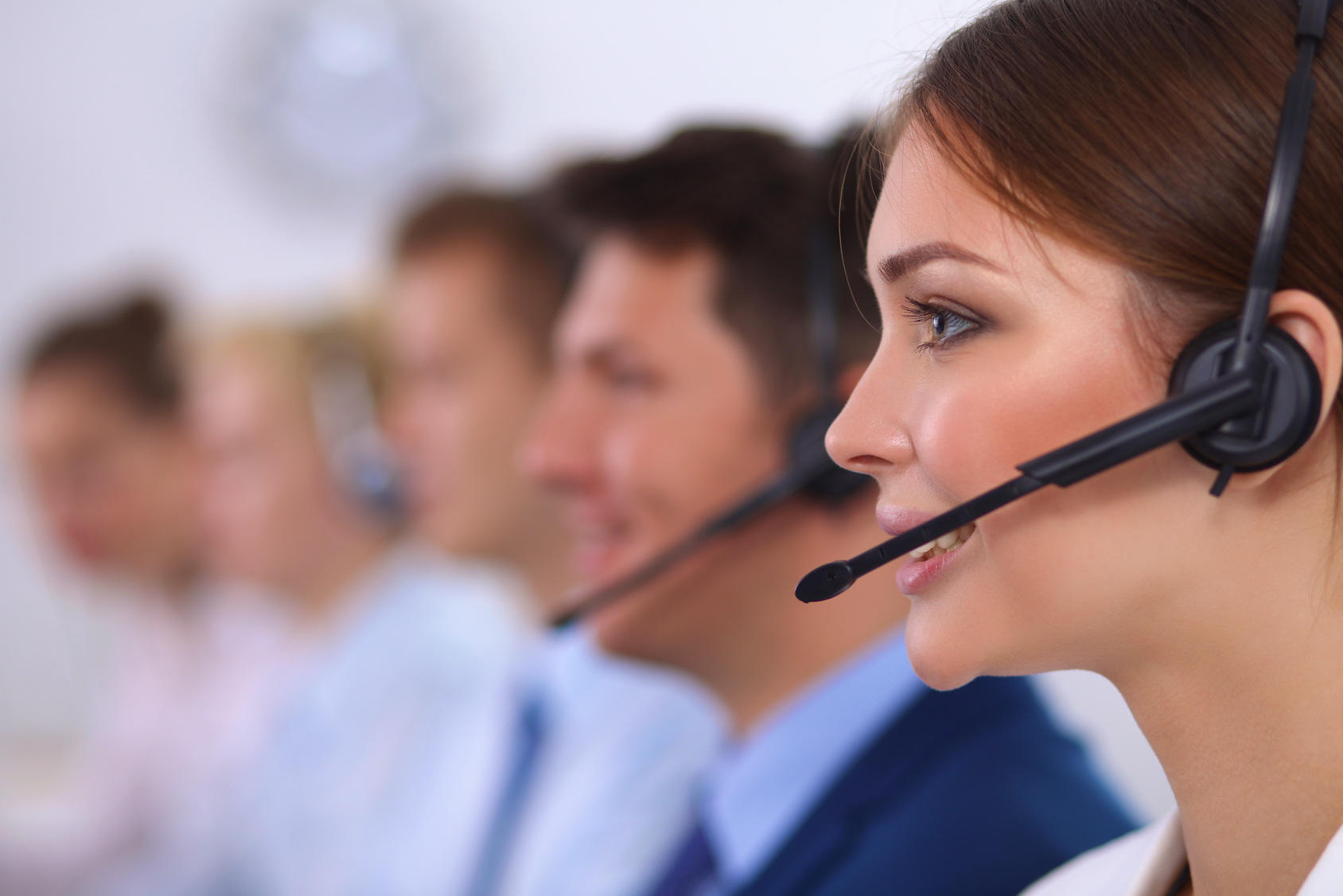 Attractive positive young businesspeople and colleagues in a call center office.